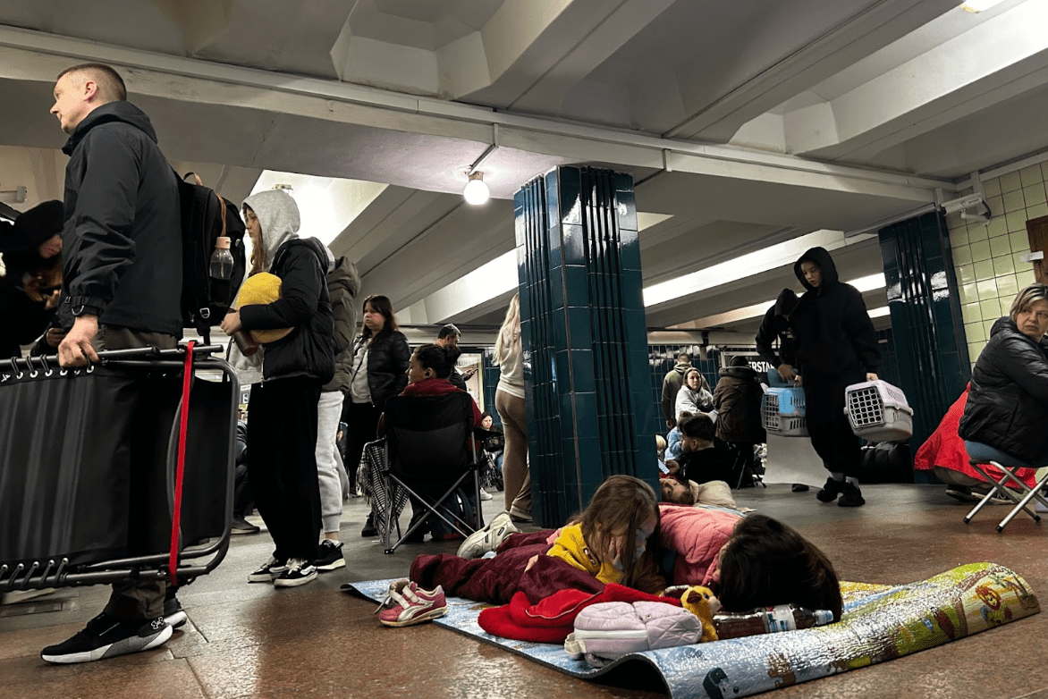 Residents arriving at the metro station while others try to rest. (Photograph by Joseph Roche)